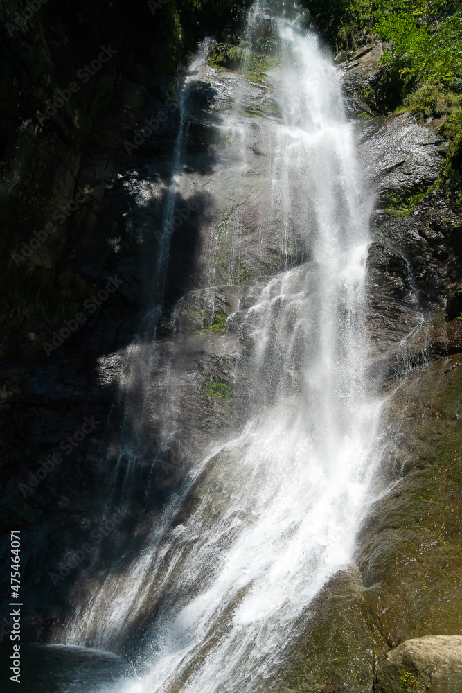 Mahuntseti Waterfall on a sunny, bright day. Georgia. Sights of Georgia. Vertical photo