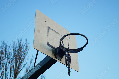 A worn basketball hoop in a public recreational area. photo