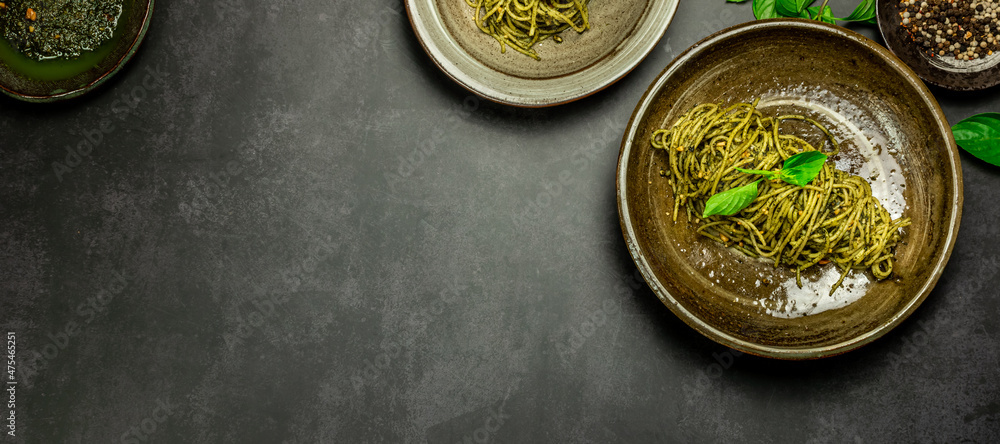 Homemade pasta spaghetti with basil pesto sauce and fresh basil leaves. Copy space. Top view. Homemade pasta spaghetti with basil pesto sauce and fresh basil leaves. Copy space. Top view.