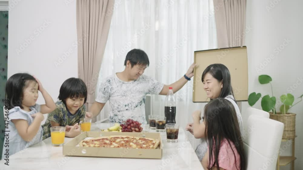 Asian family, parents and daughter, young girl sitting on a chair with open boxes of pizza and drinks party. on the dining table In the house at home, celebrating New Year's Day, birthday, long vacati Asian family, parents and daughter, young girl sitting on a chair with open boxes of pizza and drinks party. on the dining table In the house at home, celebrating New Year's Day, birthday, long vacati