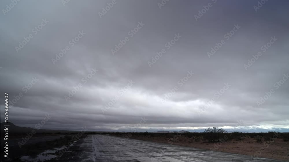 Cloudscape over a wet Mojave Desert road through the wilderness after a rare winter thundershower - time lapse Cloudscape over a wet Mojave Desert road through the wilderness after a rare winter thundershower - time lapse