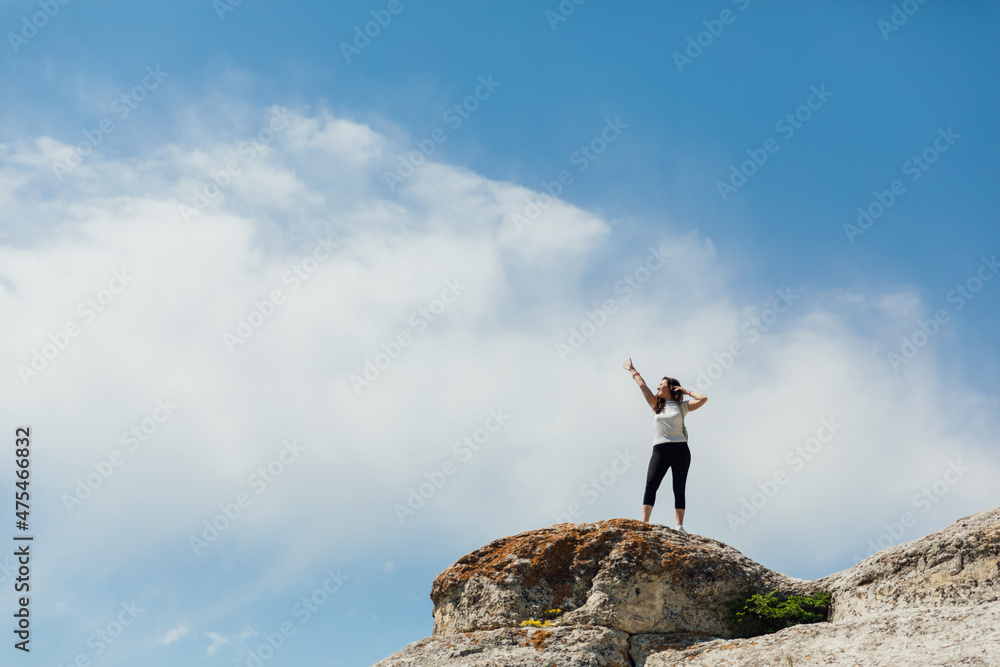 beautiful female traveler standing on top of a mountain on a hike beautiful female traveler standing on top of a mountain on a hike