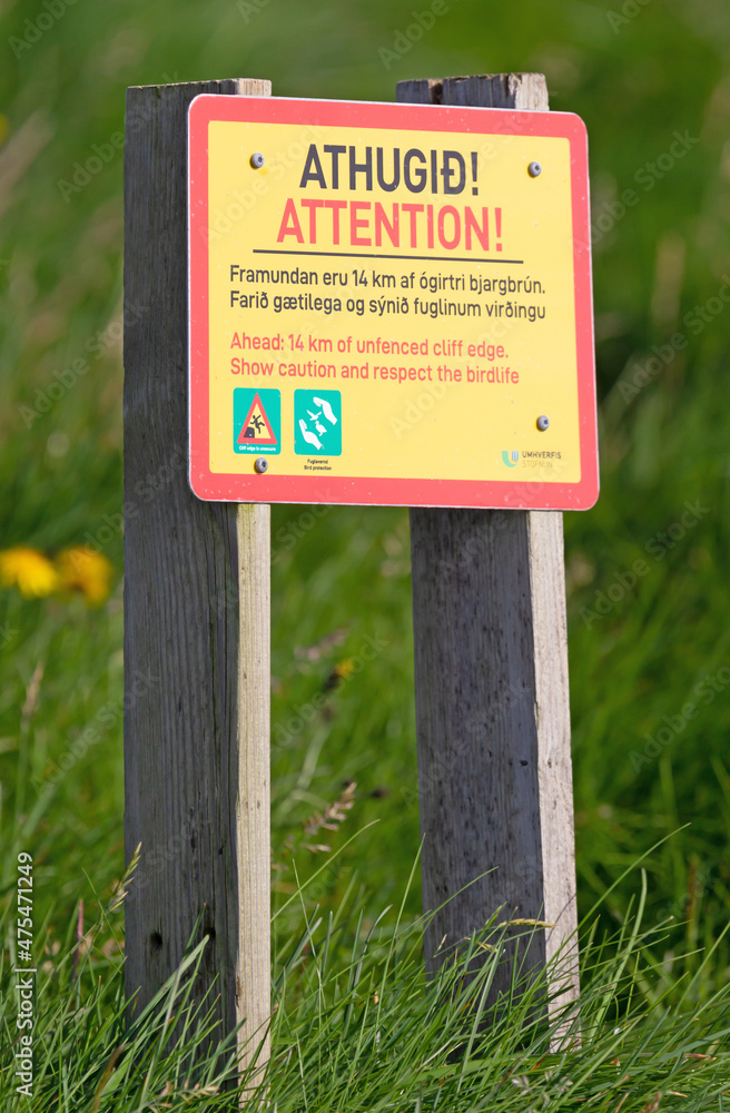 Yellow colored warning sign at the Latrabjarg