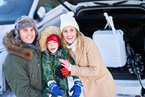 Young family during winter trip car trunk in bacground
