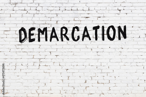 Fotografija White wall with black paint inscription demarcation on it