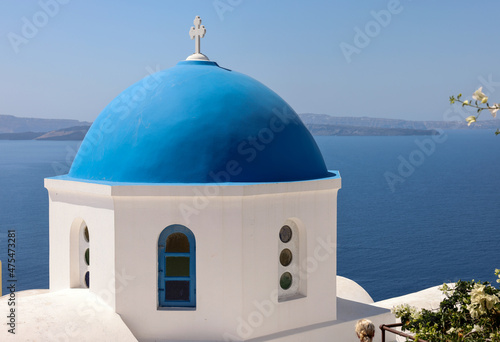 View from viewpoint of Oia village with blue dome of greek orthodox Christian church. Santorini, Greece