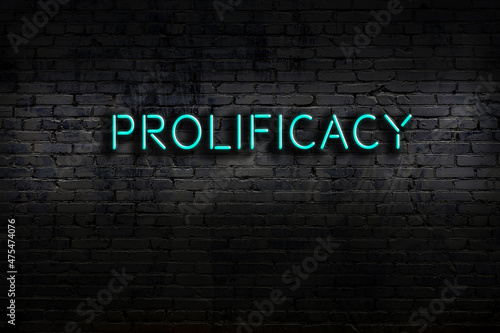 Night view of neon sign on brick wall with inscription prolificacy photo