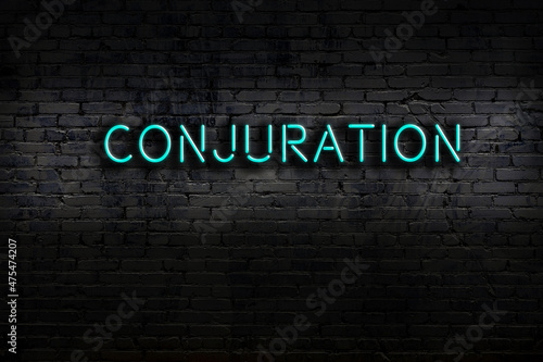 Fotografia Neon sign. Word conjuration against brick wall. Night view