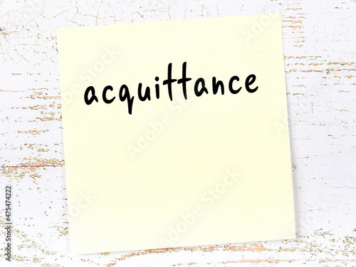 Yellow sheet of paper with word acquittance. Reminder concept