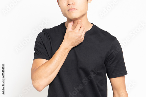 白い背景の前に立って喉が痛いポーズをする黒いTシャツを着ている男性 photo