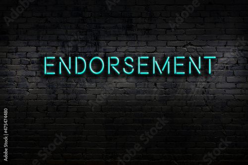 Neon sign. Word endorsement against brick wall. Night view photo