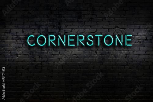 Print op canvas Night view of neon sign on brick wall with inscription cornerstone