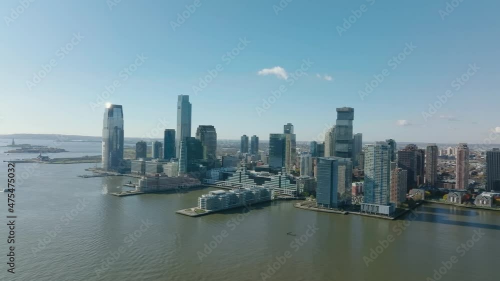 Aerial panoramic view of tall apartment or office buildings on Hudson river waterfront. Two long piers protruding into water. Jersey City, USA Aerial panoramic view of tall apartment or office buildings on Hudson river waterfront. Two long piers protruding into water. Jersey City, USA