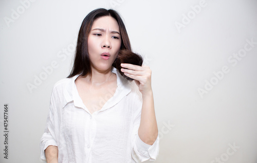 Asian Beautiful woman are looking at hair tip with worry about hair split and dry problem © Nitcharee