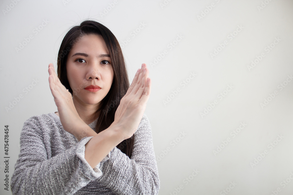 Asian Beautiful woman are raise hand and crossing to make forbidden and stop symbol with serious face. Asian Beautiful woman are raise hand and crossing to make forbidden and stop symbol with serious face.
