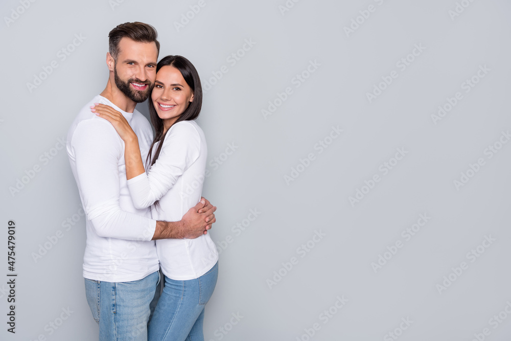 Portrait of attractive cute cheerful couple cuddling copy blank empty place space ad isolated over grey pastel color background Portrait of attractive cute cheerful couple cuddling copy blank empty place space ad isolated over grey pastel color background