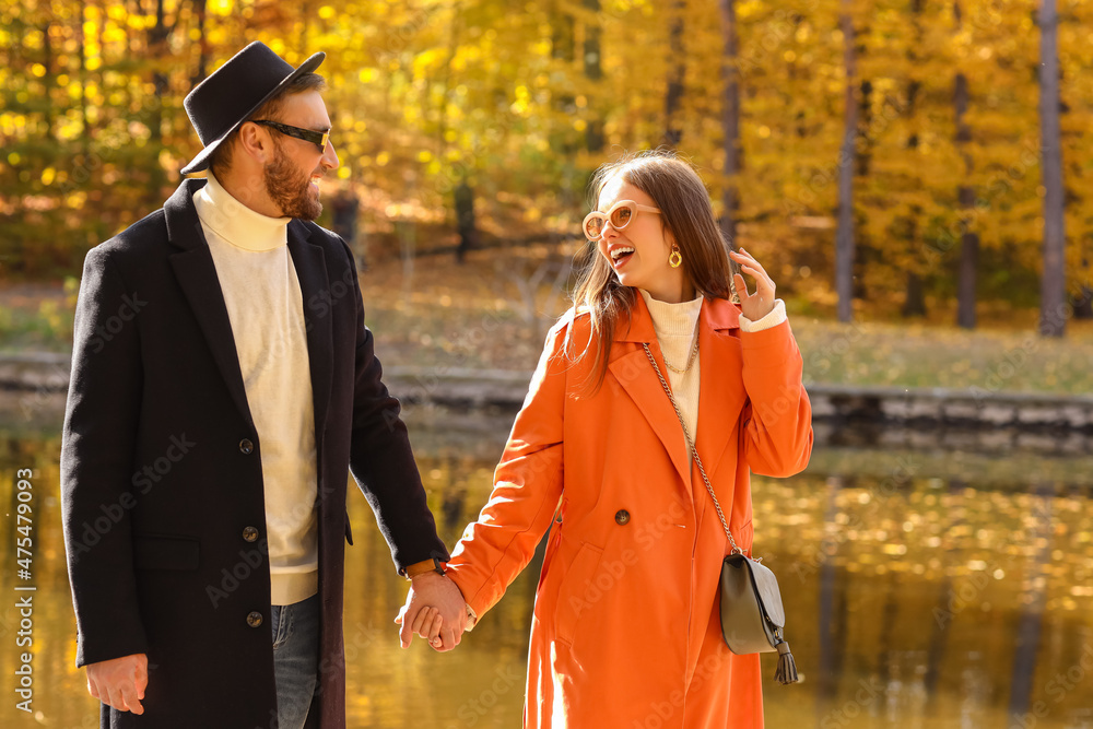 Young couple walking near water in autumn park Young couple walking near water in autumn park
