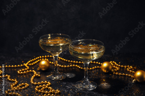 Glasses with champagne and beautiful Christmas decorations on dark background photo