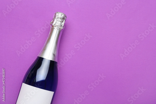 Bottle of champagne on purple background