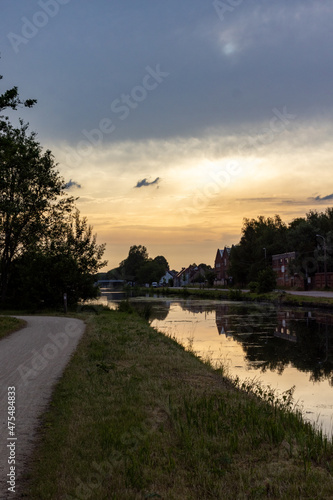 Golden Sunrise on the water of the canal or river flowing through a natural forest landscape. High quality photo