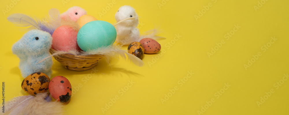 Bunny toys and Easter eggs, feathers and nest. Happy easter concept. Copy space, banner