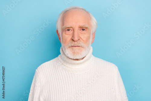 Portrait of attractive calm grey-haired man wearing cosy warm pullover isolated over bright blue color background