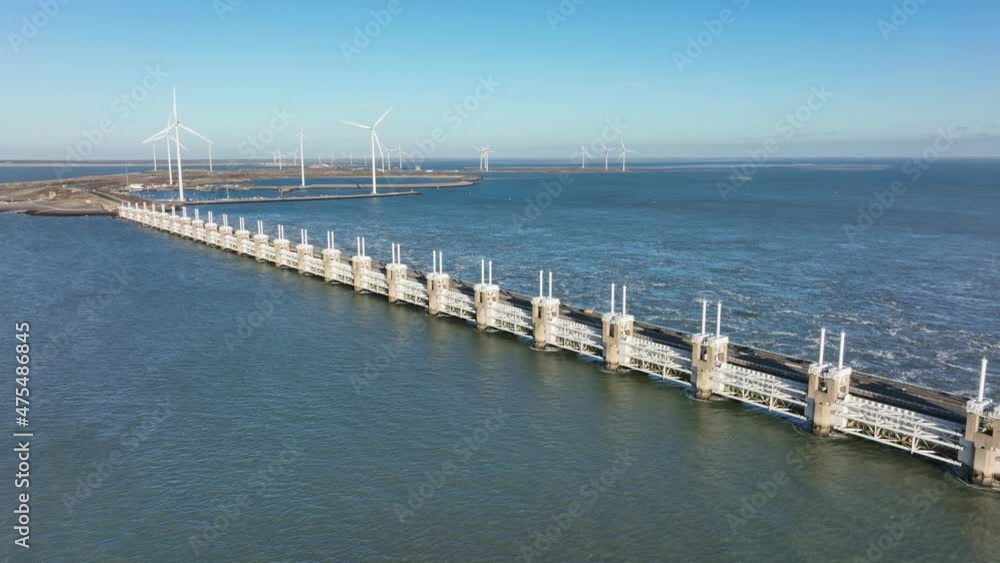 Aerial slow motion shot of the Eastern Scheldt storm surge barrier and wind turbines in Zeeland, the Netherlands on a beautiful sunny day Aerial slow motion shot of the Eastern Scheldt storm surge barrier and wind turbines in Zeeland, the Netherlands on a beautiful sunny day
