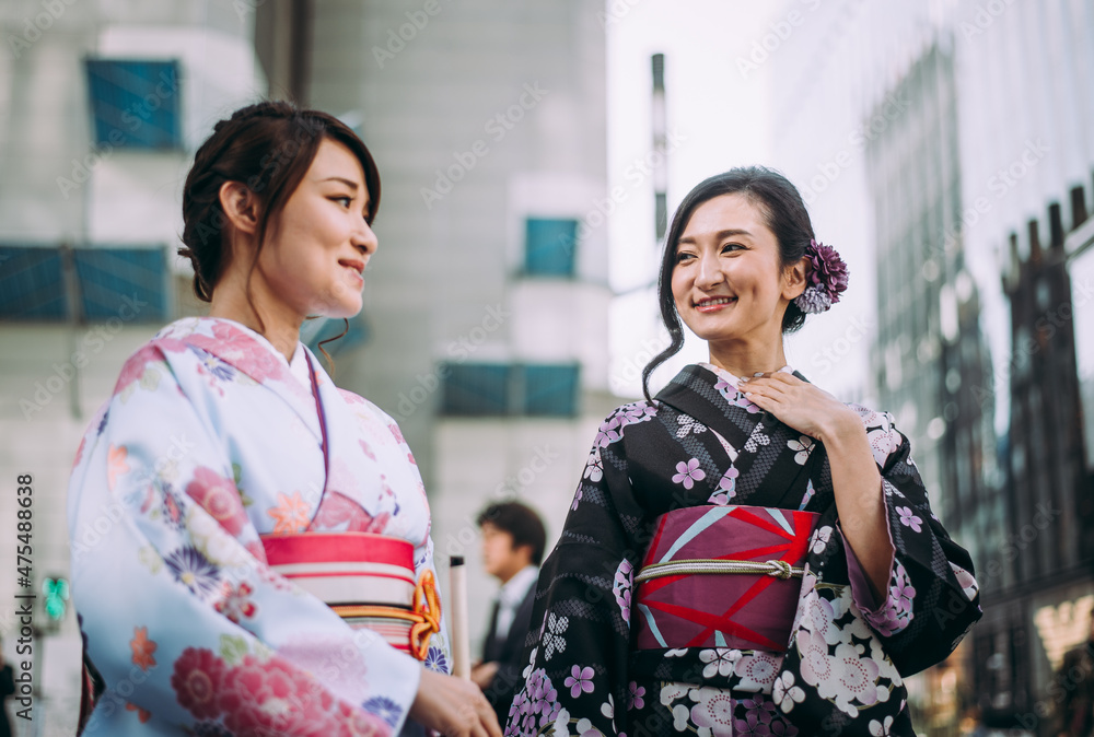 Storytelling image of two japanese girls wearing kimono spending time in Tokyo. Traditional clothes lifestyle moments from the local culture in Japan
