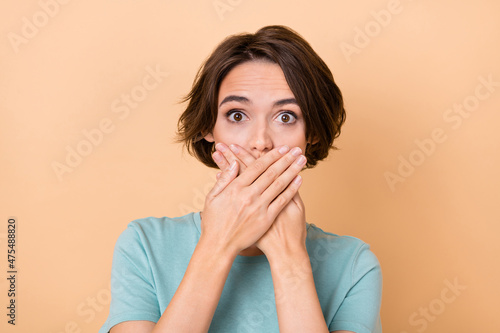 Photo of young lady cover mouth hands nervous tell confidential information isolated over beige color background