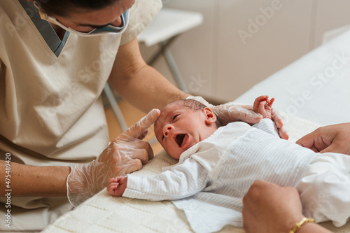 Physiotherapist evaluating the asymmetric tonic reflex in a newborn baby. photo