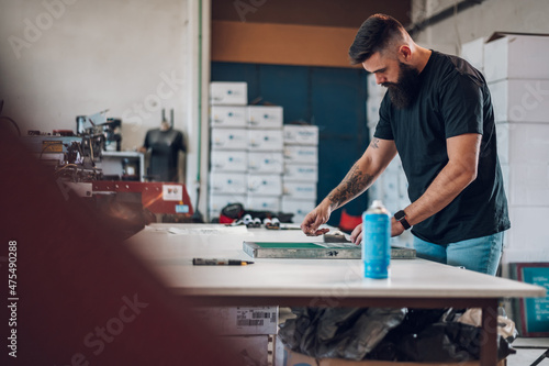 Male worker preparing screen printing film in workshop