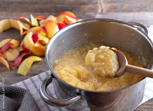 Photos Homemade apple sauce in a pot with wooden spoon