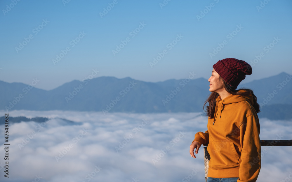 Portrait of a young female traveler with a beautiful mountain and sea of fog in the morning