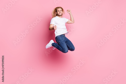 Full size photo of attractive young happy lady jump up winner triumph isolated on pastel pink color background © deagreez