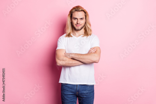 Photo of charming young positive man hold hands crossed good mood isolated on pink color background