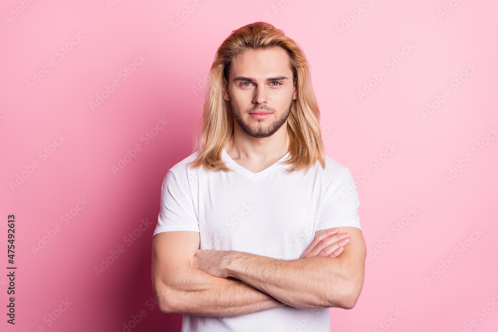 Photo of serious young confident man hold hands crossed calm face isolated on pastel pink color background Photo of serious young confident man hold hands crossed calm face isolated on pastel pink color background