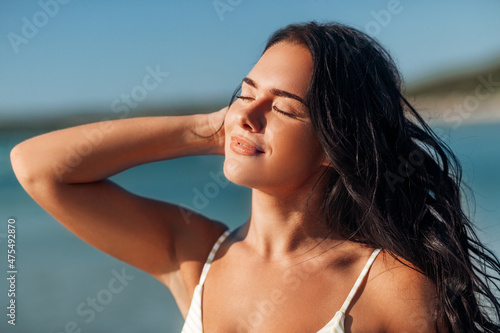 people, summer and swimwear concept - happy beautiful young woman in bikini swimsuit on beach