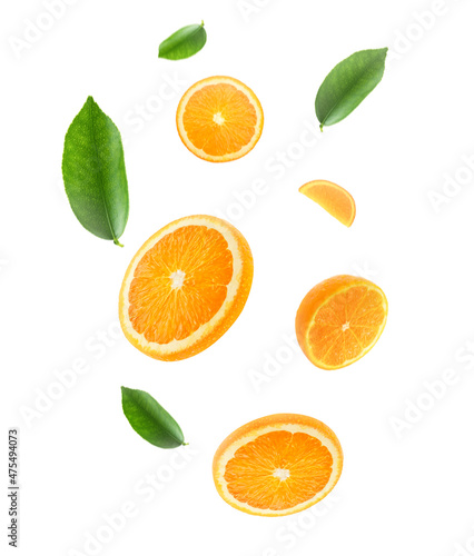Falling juicy oranges with green leaves isolated on transparent background. Flying defocusing slices of oranges. Applicable for fruit juice advertising