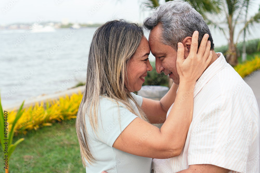 Latin couple, standing in the park, embrace affectionately. Latin couple, standing in the park, embrace affectionately.