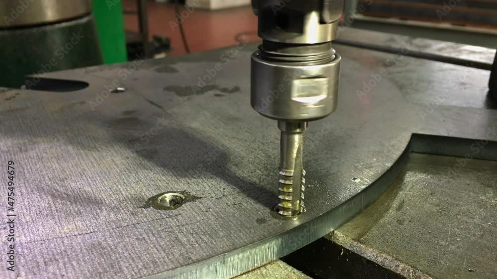 Threading in the hole of the iron billet. Professional tool for drilling and threading. Metalworking. Threading in the hole of the iron billet. Professional tool for drilling and threading. Metalworking.