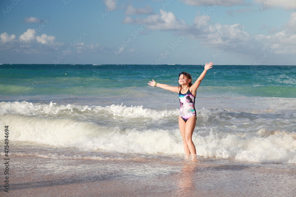 Happy little girl jumps in sore water at Bavaro beach Happy little girl jumps in sore water at Bavaro beach