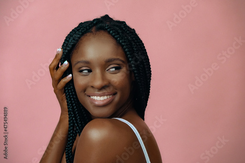 close up smiling african american young adult woman on pink background