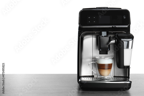 Fototapeta Naklejka Na Ścianę i Meble -  Modern coffee machine with glass cup of latte on wooden table against white background. Space for text