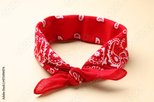 Tied red bandana with paisley pattern on beige background