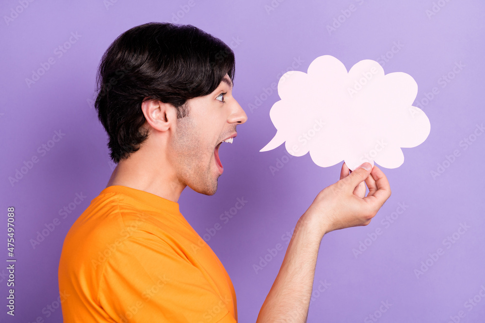 Profile side photo of happy positive young man hold hand cloud banner news isolated on purple color background Profile side photo of happy positive young man hold hand cloud banner news isolated on purple color background