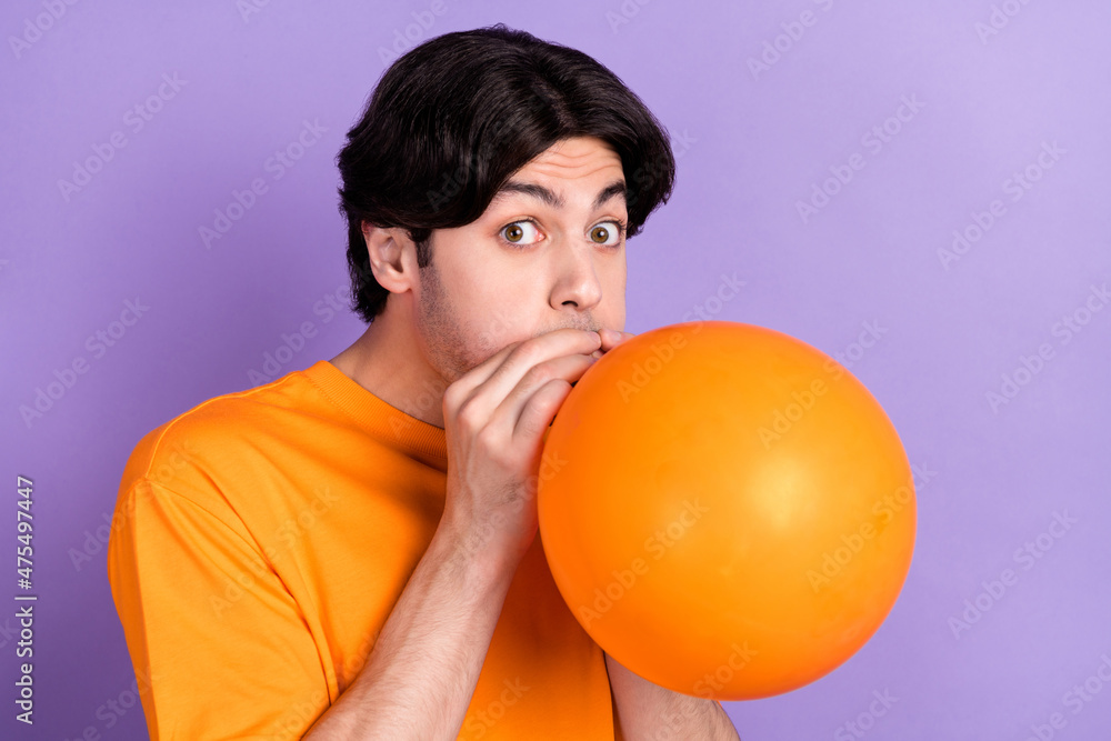 Photo of amazed positive funny man blow air balloon festive celebrate isolated on purple violet color background Photo of amazed positive funny man blow air balloon festive celebrate isolated on purple violet color background