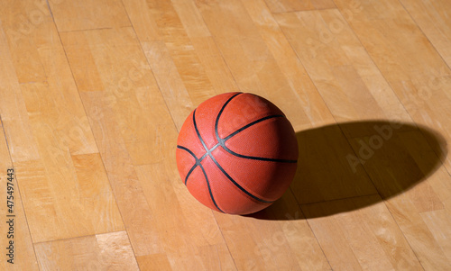 Basketball on hardwood court floor with lighting. Workout online concept. Horizontal sport theme poster, greeting cards, headers, website and app