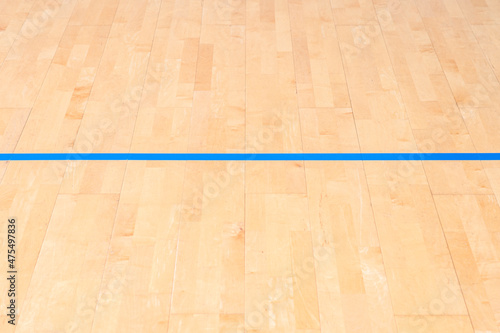 Wooden floor  basketball  badminton  futsal  handball  volleyball  football  soccer court. Wooden floor of sports hall with marking blue lines on wooden floor indoor  gym court