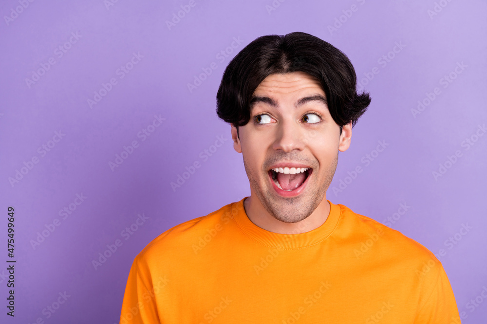 Photo of young amazed shocked man look empty space news sale isolated on purple violet color background Photo of young amazed shocked man look empty space news sale isolated on purple violet color background