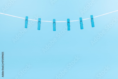 Colorful cartoon clothespins on the blue background.